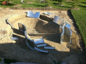 The pool panels for a custom swimming pool set in the excavated hole