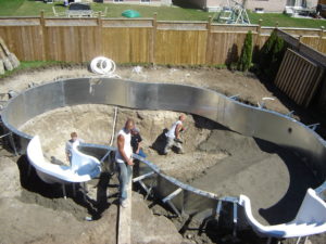 A pool crew busy installing the bottom of a custom swimming pool