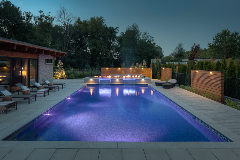 Nighttime image of custom backyard swimming pool