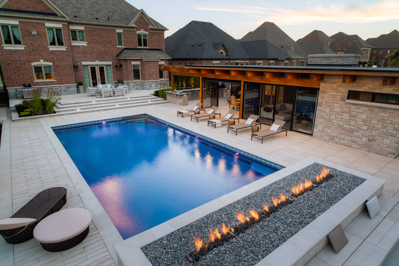 A vinyl swimming pool with outdoor firepit feature