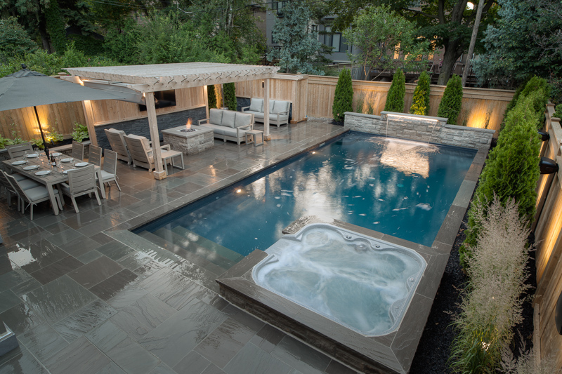 A backyard swimming pool with attached spill over spa