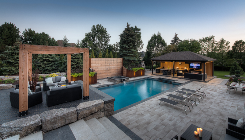 Backyard swimming pool with waterfall features and cabana